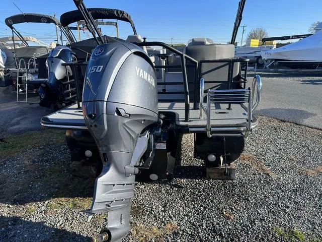 Slide: The Image of 2025 Starcraft SLS 1 pontoon boat with Yamaha 150 outboard motor, parked on gravel. - 8
