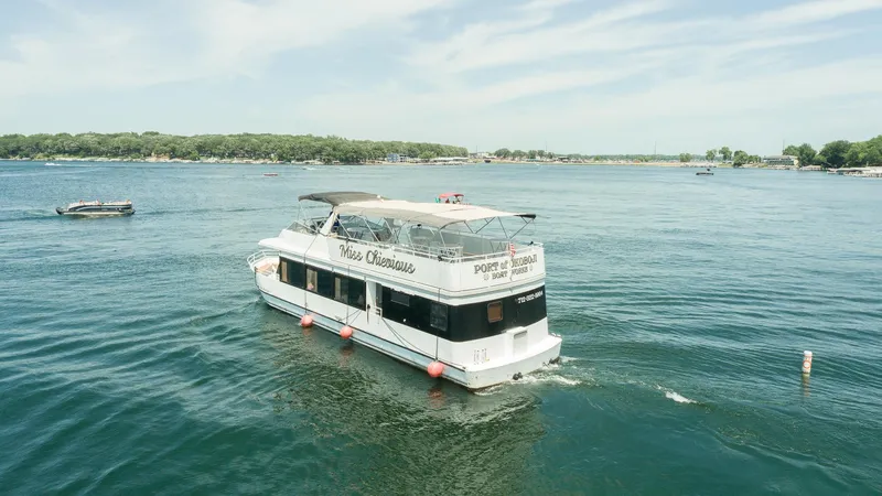 Slide: The Image of Upper deck of a 1994 Skipperliner 5800 with seating and tables, docked at a marina. - 12