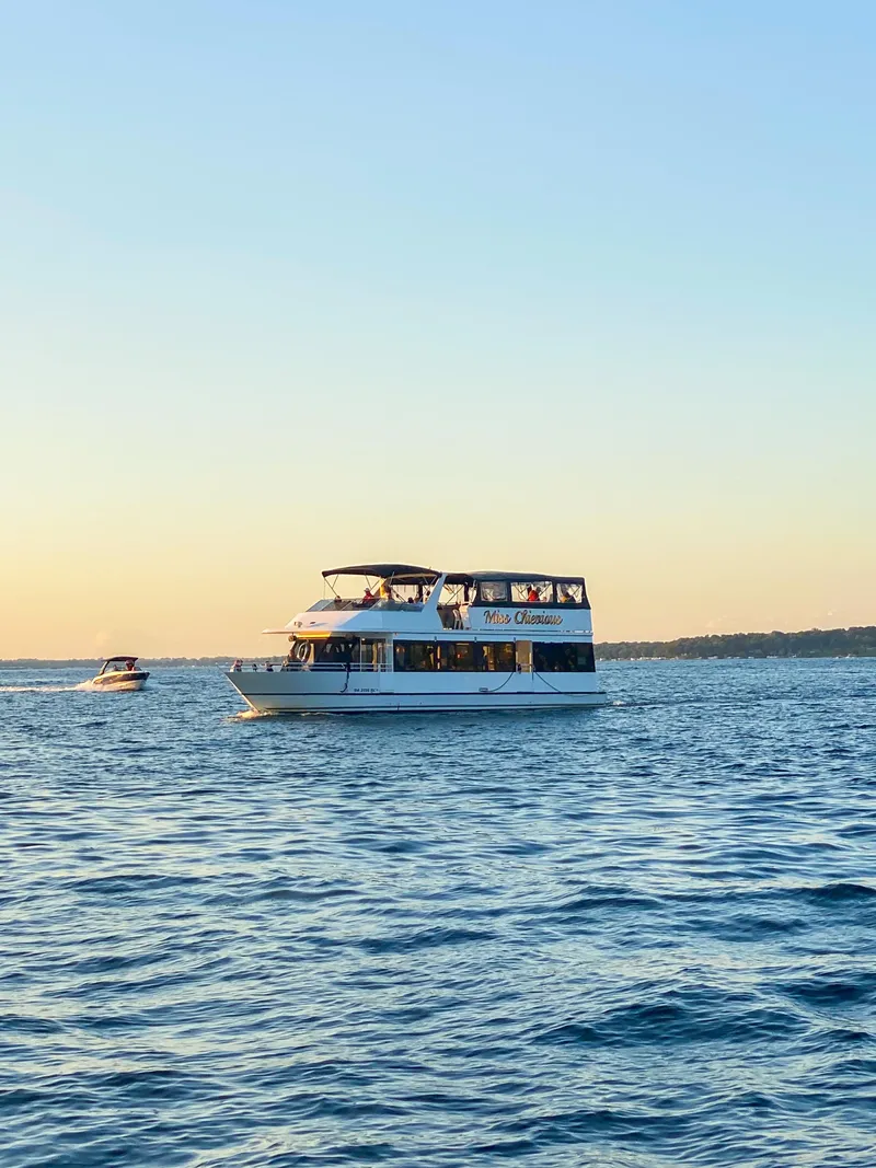 Slide: The Image of 1994 Skipperliner 5800 boat cruising on a serene lake under a clear sky. - 14