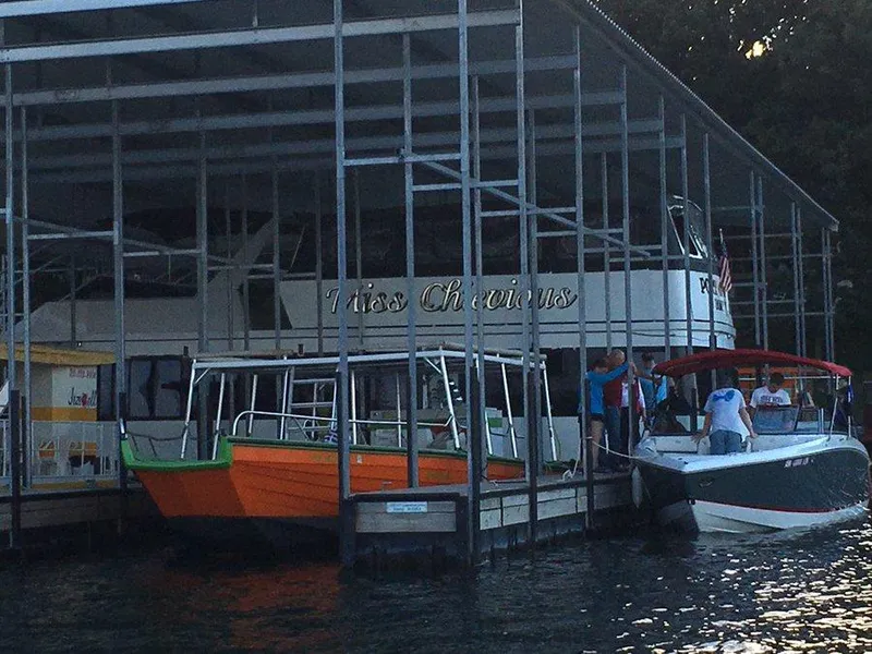 Slide: The Image of 1994 Skipperliner 5800 docked, featuring "Miss Chievous" signage, under a covered marina. - 2