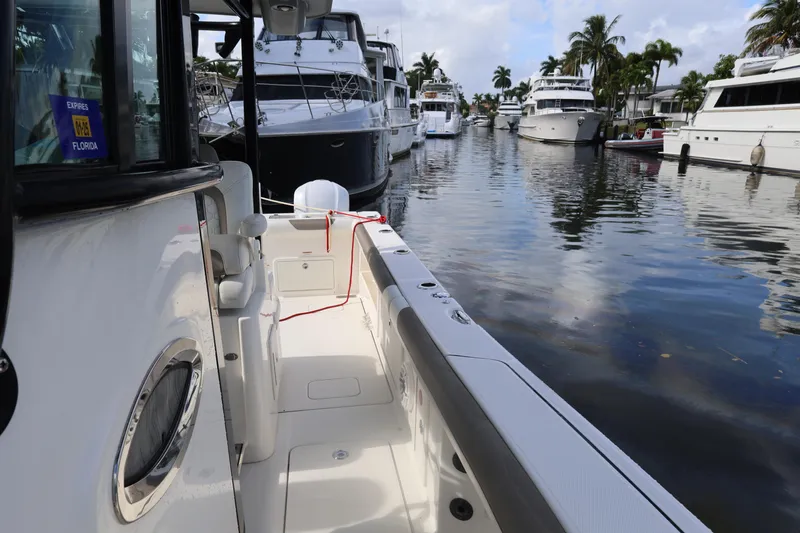 Slide: The Image of 2020 World Cat 325 CC boat docked in a marina with other vessels. - 15