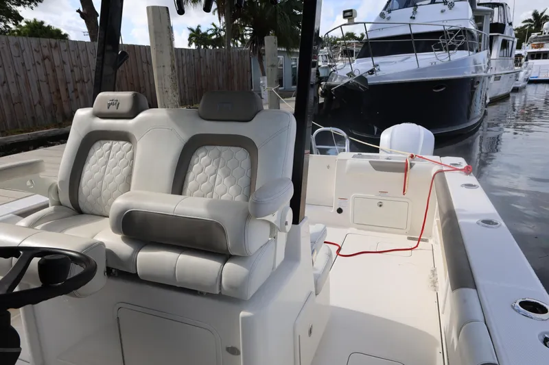 Slide: The Image of 2020 World Cat 325 CC boat interior with plush seating at a marina. - 16