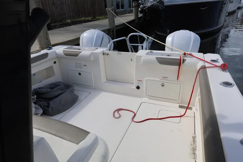 Slide: The Image of 2020 World Cat 325 CC boat interior with twin engines and docked at marina. - 17