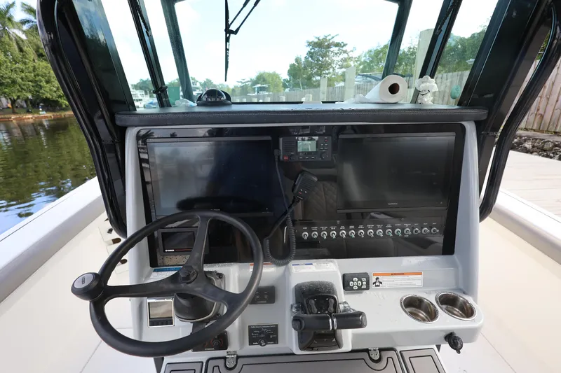 Slide: The Image of 2020 World Cat 325 CC boat dashboard with steering wheel and navigation controls. - 21