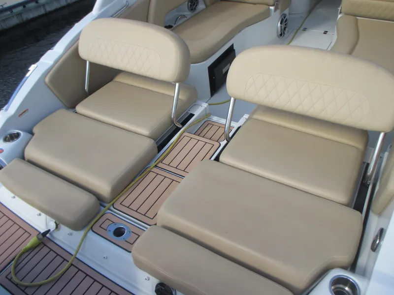 Slide: The Image of 2018 Crownline Eclipse E29 XS boat interior with beige seating and wood-style flooring. - 21