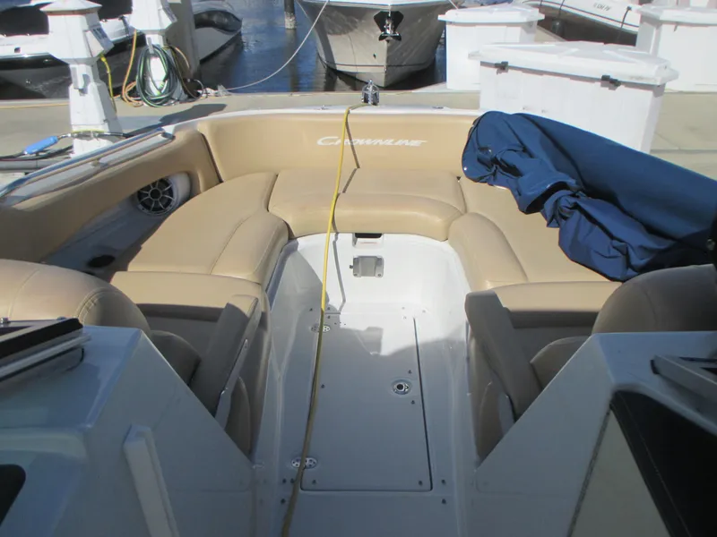 Slide: The Image of 2018 Crownline Eclipse E29 XS boat interior with tan seating and blue cover. - 25