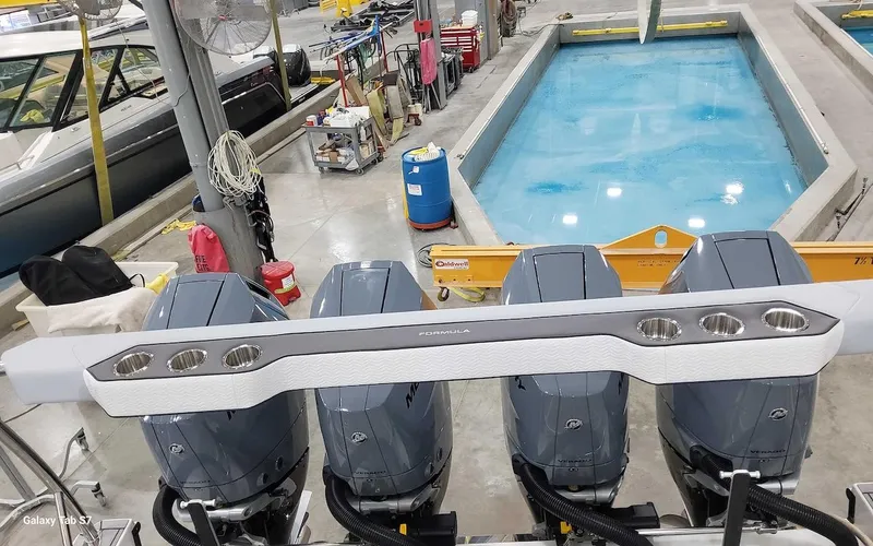 Slide: The Image of 2024 Formula 430 Super Sport Crossover in a workshop with four powerful outboard engines. - 12