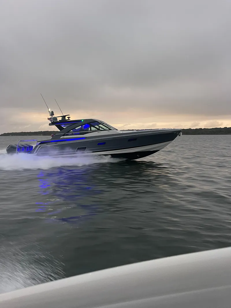 Slide: The Image of 2024 Formula 430 Super Sport Crossover cruising on a calm lake at sunset. - 2