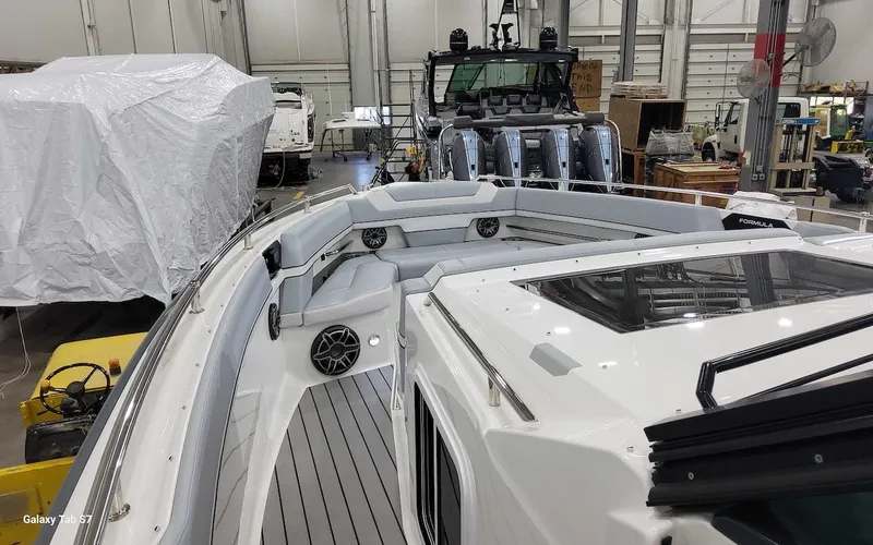 Slide: The Image of 2024 Formula 430 Super Sport Crossover in a boatyard, showcasing sleek design and spacious deck. - 28