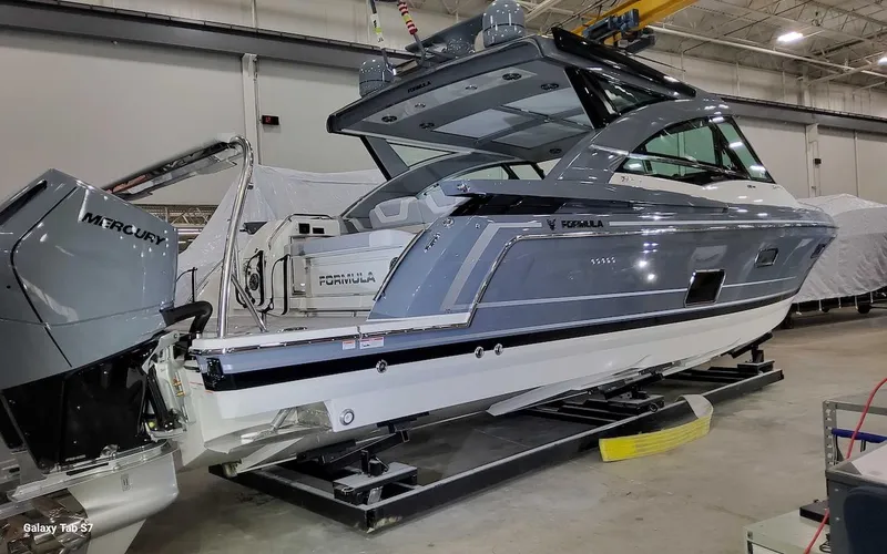 Slide: The Image of 2024 Formula 430 Super Sport Crossover boat in showroom, featuring sleek design and Mercury engines. - 9