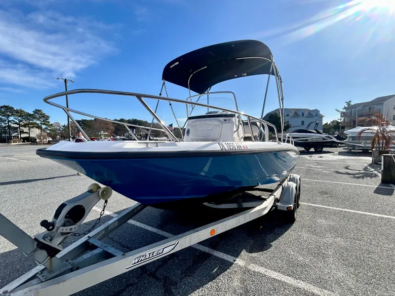 Slide: The Image of 2011 Boston Whaler DAUNTLESS 180/CC boat on trailer, sunny day, parking lot. - 1