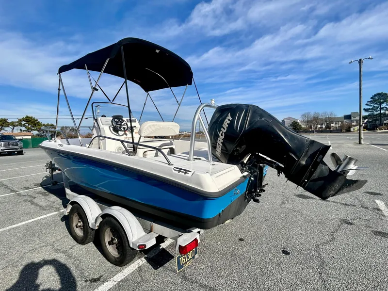 Slide: The Image of 2011 Boston Whaler DAUNTLESS 180/CC boat on trailer, blue hull, parked outdoors. - 4
