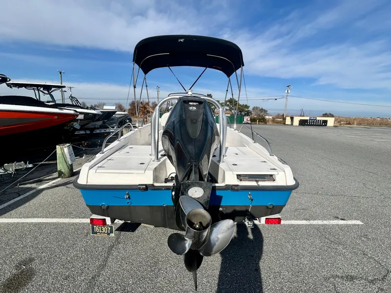 Slide: The Image of 2011 Boston Whaler DAUNTLESS 180/CC boat with outboard motor and canopy, parked outdoors. - 6