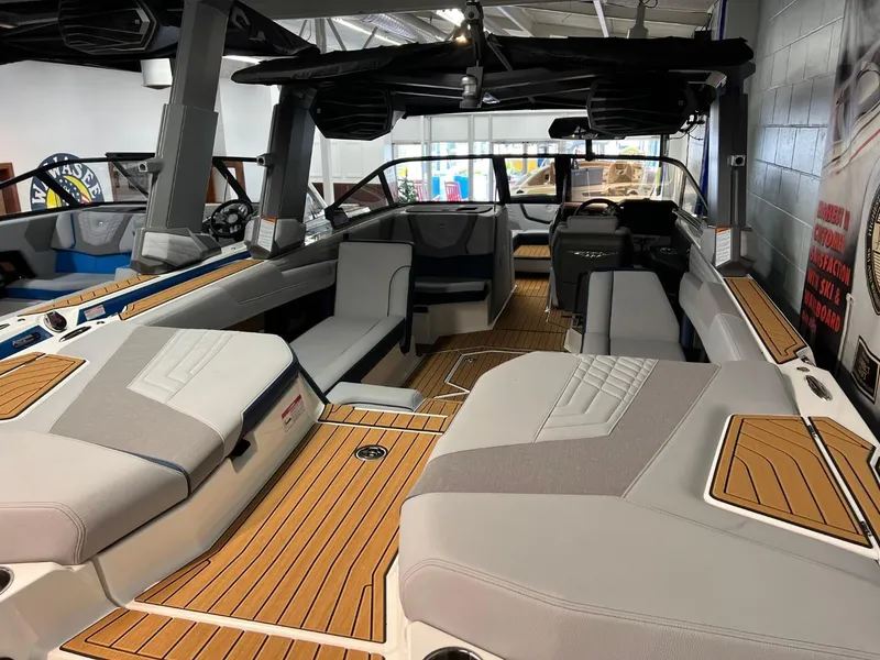 Slide: The Image of 2023 Nautique Super Air Nautique G25 interior with luxurious seating and teak flooring. - 12
