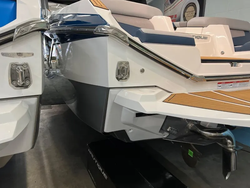 Slide: The Image of 2023 Nautique Super Air Nautique G25 boat rear view in showroom. - 13