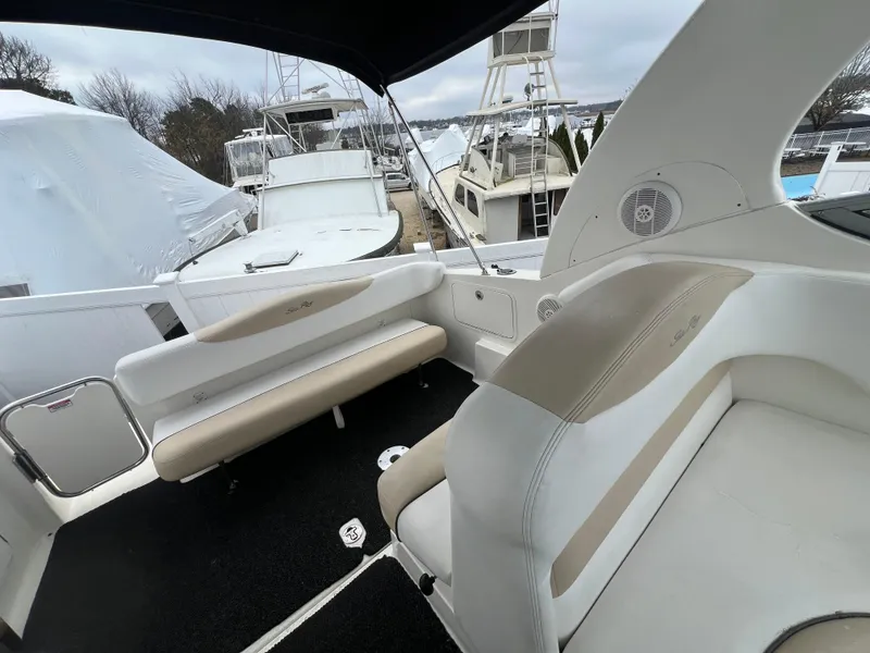 Slide: The Image of 2008 Sea Ray 280 Sundancer boat interior with beige seating and black flooring. - 13