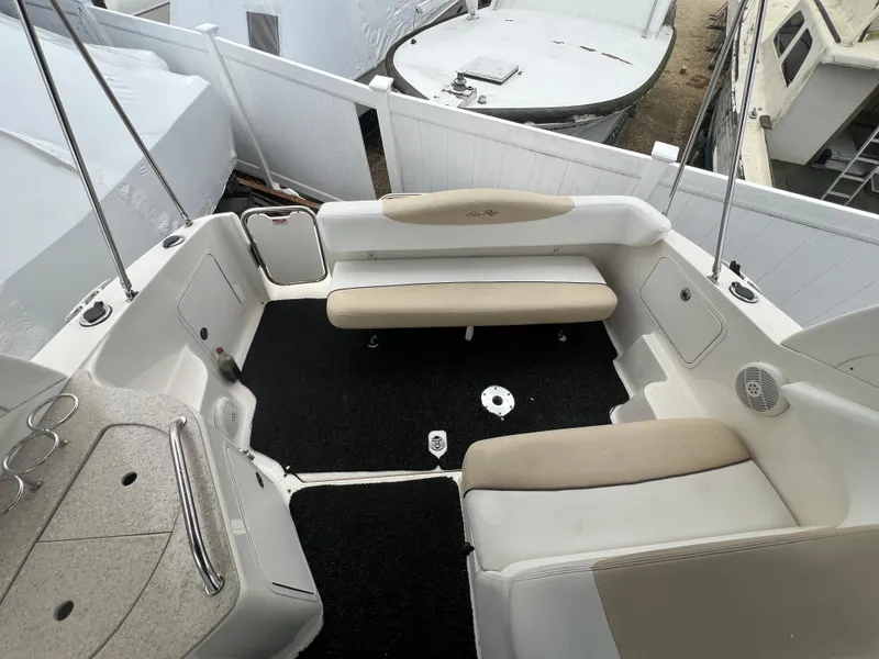 Slide: The Image of 2008 Sea Ray 280 Sundancer boat interior with beige seating and black carpet. - 15