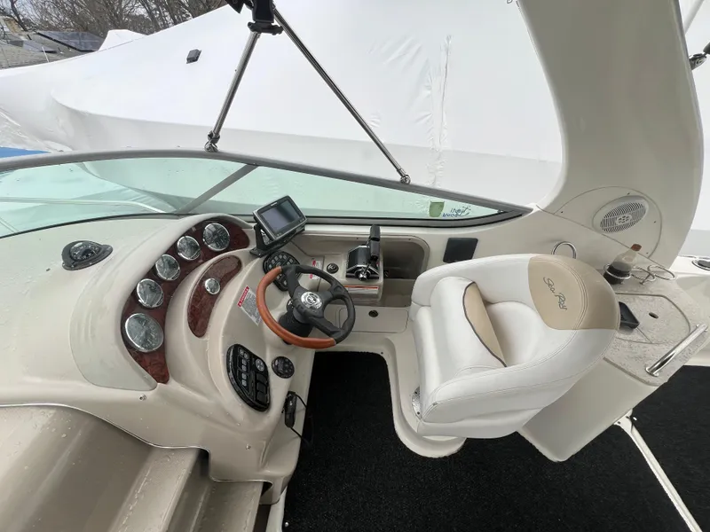 Slide: The Image of 2008 Sea Ray 280 Sundancer helm with steering wheel, gauges, and white captain's chair. - 2