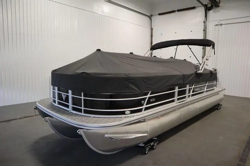 Slide: The Image of 2025 Trifecta 24RF LE 2.75 pontoon boat with black cover in a garage. - 46
