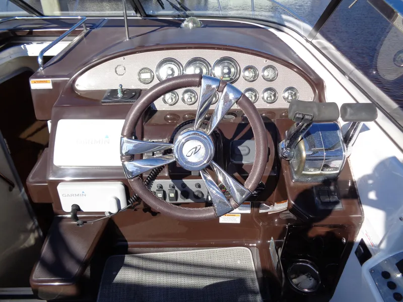 Slide: The Image of 2014 Regal 3060 Window Express boat dashboard with steering wheel and controls. - 16