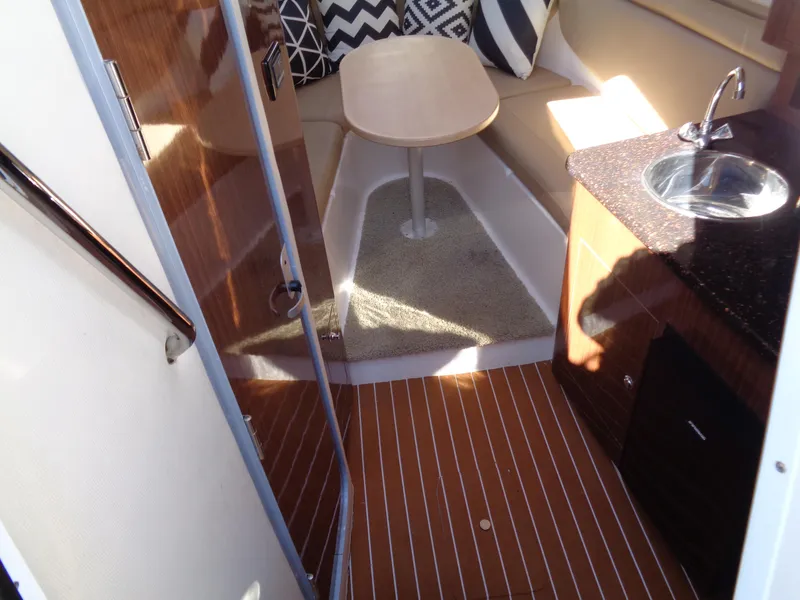 Slide: The Image of 2014 Regal 3060 Window Express cabin interior with wood flooring and compact kitchenette. - 21