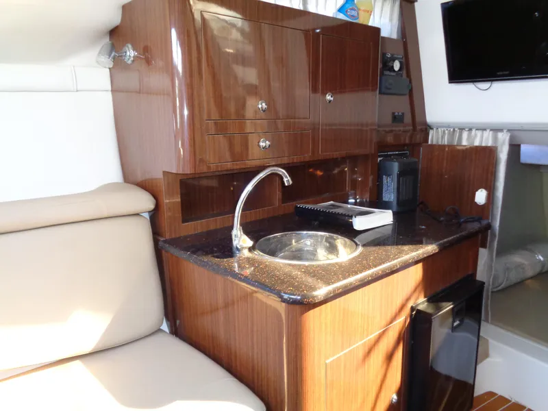 Slide: The Image of 2014 Regal 3060 Window Express yacht interior with kitchenette and seating area. - 28