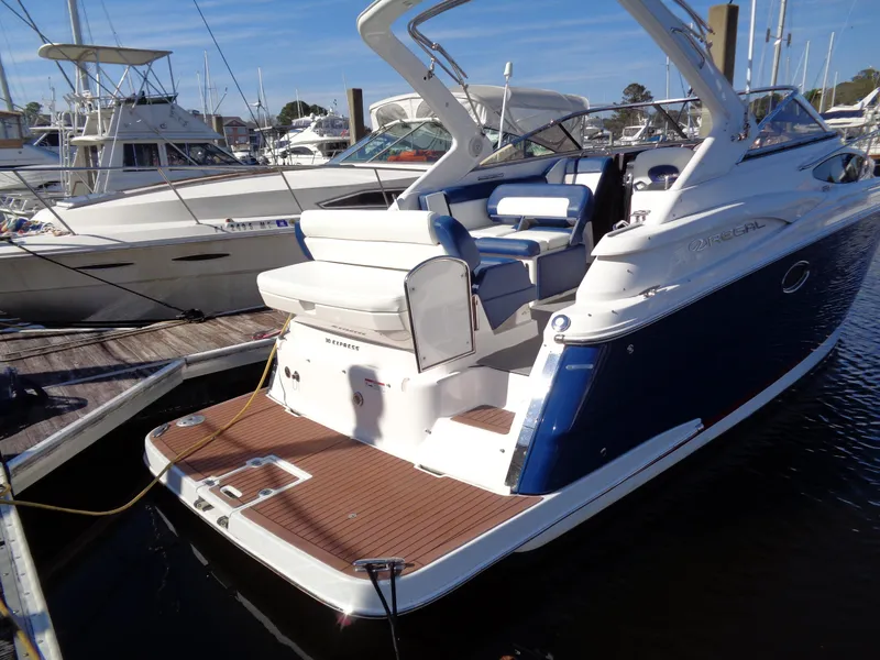 Slide: The Image of 2014 Regal 3060 Window Express boat docked at marina, featuring sleek design and spacious deck. - 3