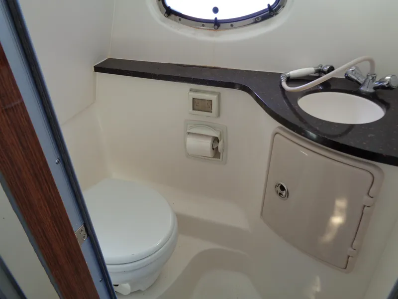 Slide: The Image of 2014 Regal 3060 Window Express bathroom with sink, toilet, and porthole window. - 32