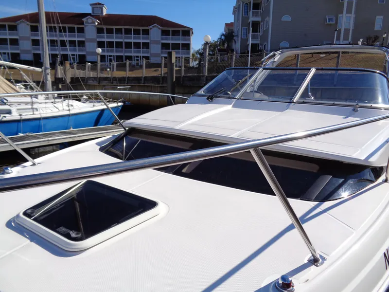 Slide: The Image of 2014 Regal 3060 Window Express boat docked near waterfront buildings. - 6