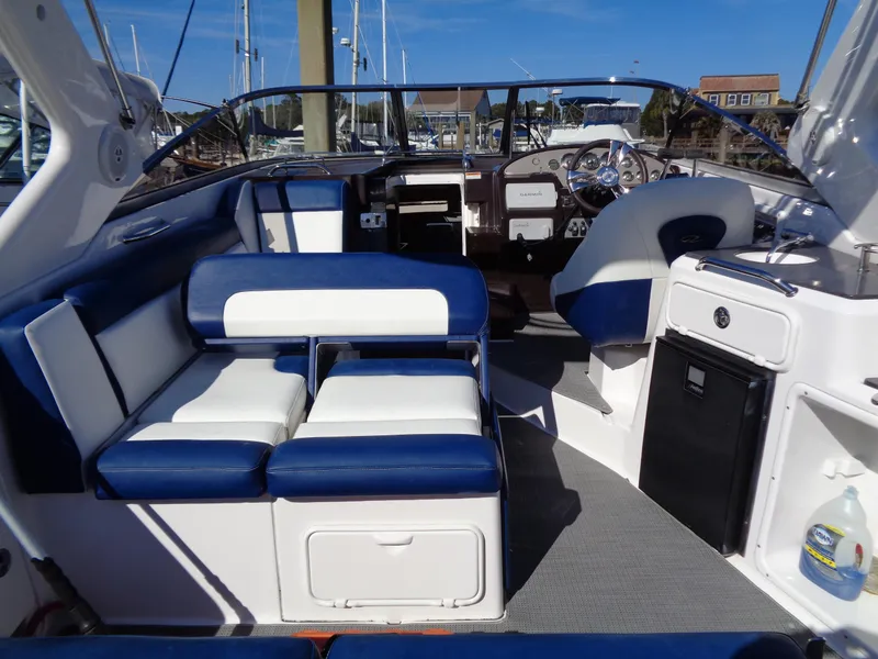 Slide: The Image of 2014 Regal 3060 Window Express boat interior with blue and white seating, steering wheel, and dashboard. - 8