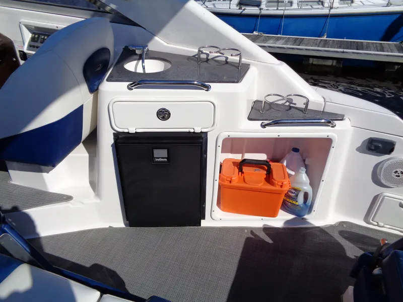 Slide: The Image of 2014 Regal 3060 Window Express boat interior with mini fridge and storage compartments. - 9