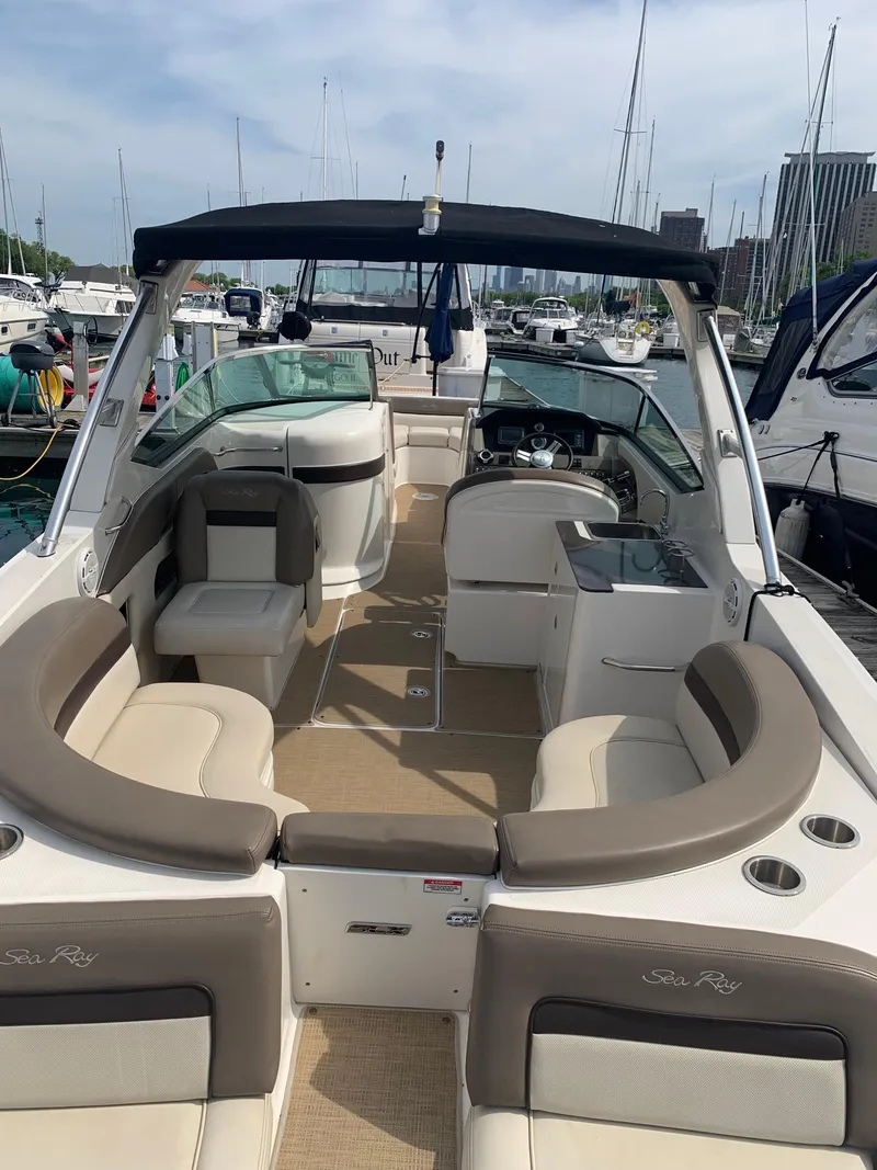 Slide: The Image of 2013 Sea Ray 300 SLX boat interior with seating and helm, docked in marina. - 11