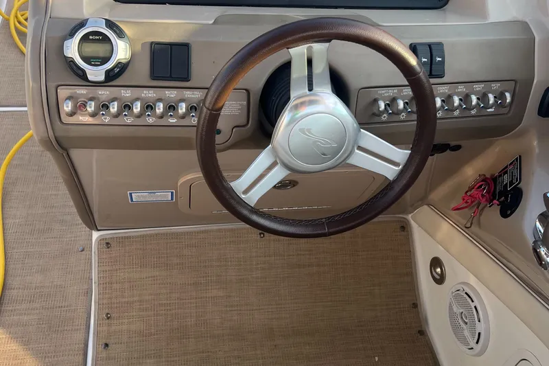 Slide: The Image of 2013 Sea Ray 300 SLX boat dashboard with steering wheel and control panel. - 15
