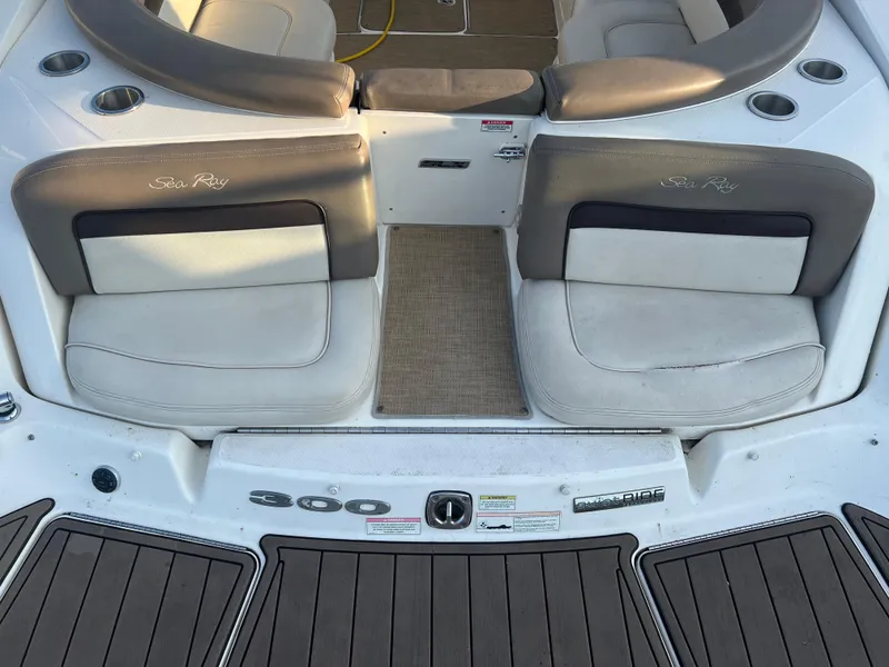 Slide: The Image of 2013 Sea Ray 300 SLX boat interior with cushioned seating and cup holders. - 4