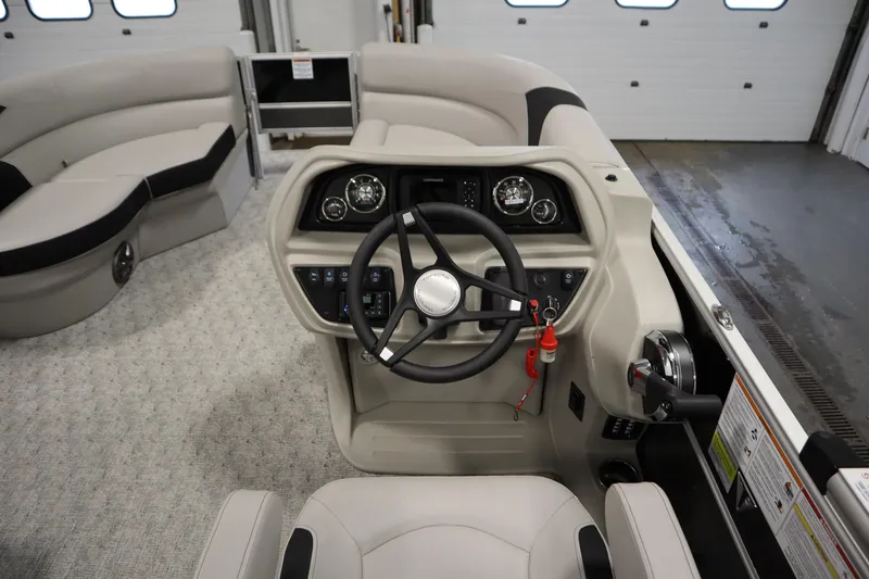 Slide: The Image of 2025 Trifecta 22TRFC LE 2.75 pontoon boat in a garage, showcasing interior seating and helm. - 14