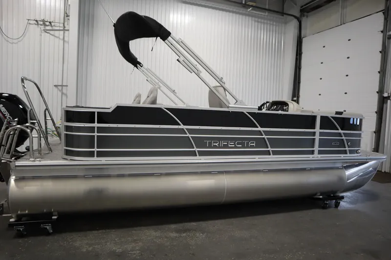 Slide: The Image of 2025 Trifecta 22TRFC LE 2.75 pontoon boat in a garage setting. - 3