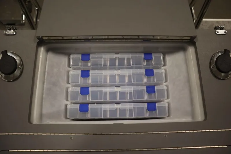 Slide: The Image of Storage compartment with organized tackle boxes in a 2025 Trifecta 22TRFC LE 2.75 boat. - 43