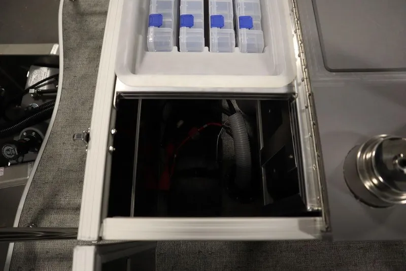 Slide: The Image of Storage compartment of 2025 Trifecta 22TRFC LE 2.75 with organized containers and wiring. - 46
