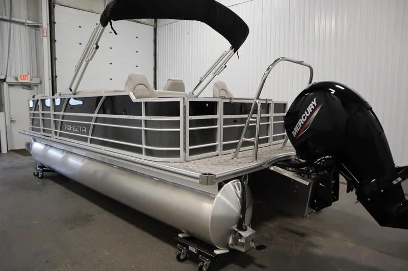Slide: The Image of 2025 Trifecta 22TRFC LE 2.75 pontoon boat with Mercury outboard motor in a garage. - 6
