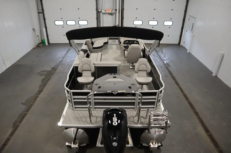 Slide: The Image of 2025 Trifecta 22TRFC LE 2.75 pontoon boat with black motor in indoor storage. - 8