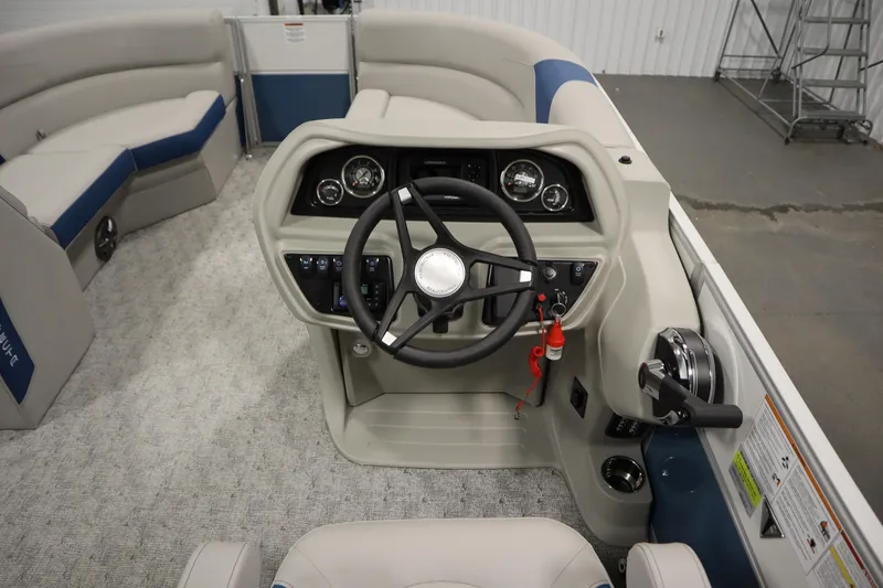 Slide: The Image of 2025 Trifecta 22RF LE 2.75 pontoon boat with spacious seating and canopy in a showroom. - 14