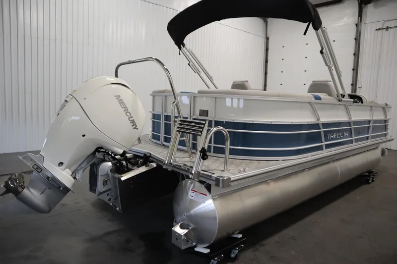 Slide: The Image of 2025 Trifecta 22RF LE 2.75 pontoon boat with Mercury outboard motor in a showroom. - 4