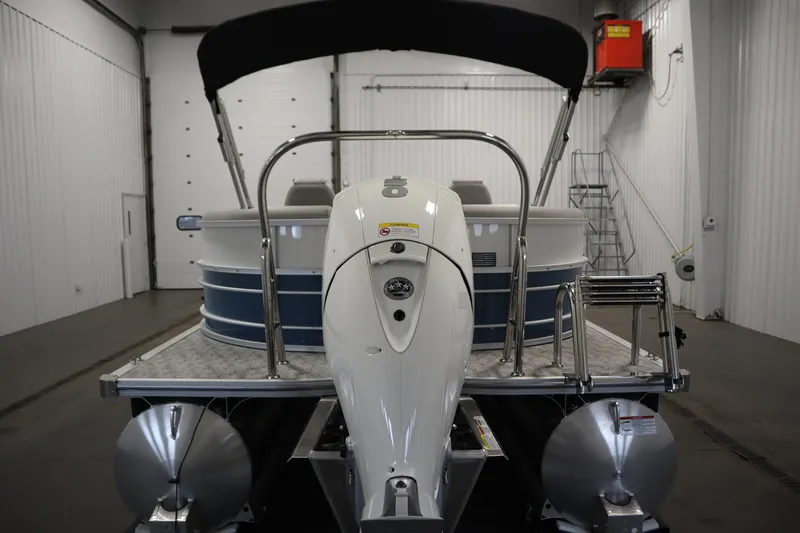 Slide: The Image of 2025 Trifecta 22RF LE 2.75 pontoon boat in a spacious indoor storage facility. - 5