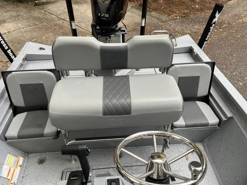 Slide: The Image of 2022 Xpress H22 boat interior with gray seating and steering wheel. - 10