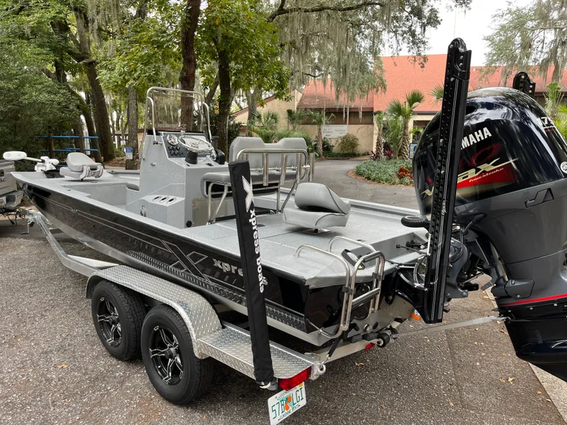 Slide: The Image of 2022 Xpress H22 boat on trailer with Yamaha outboard motor, parked outdoors. - 2