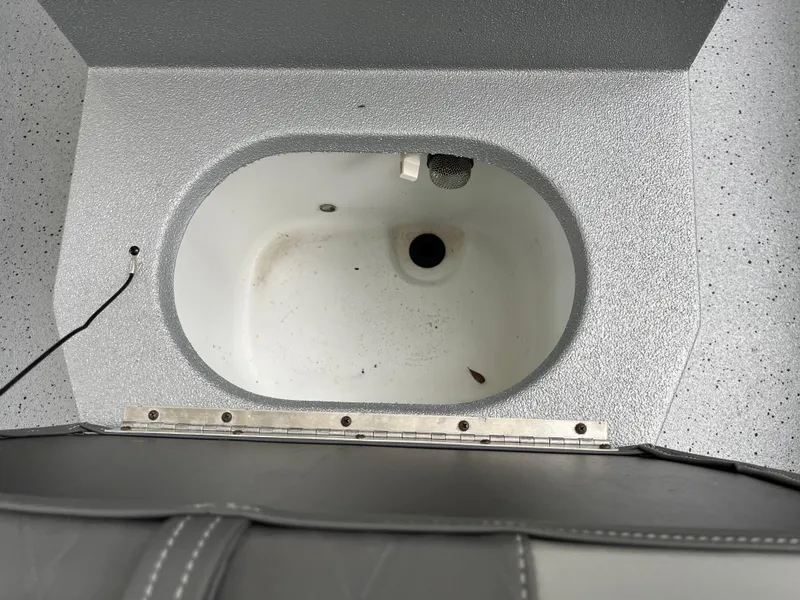 Slide: The Image of 2022 Xpress H22 boat livewell interior with drain and textured surface. - 21