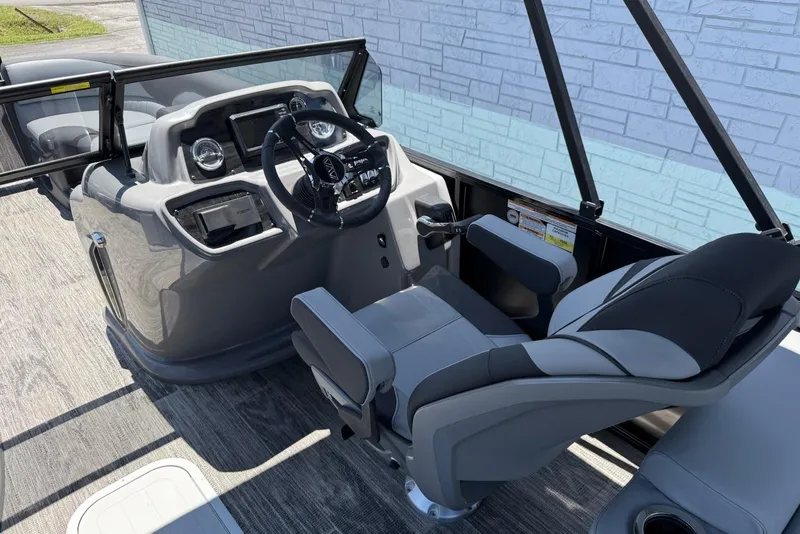 Slide: The Image of 2025 Avalon 2385 LSZ Elite Windshield boat interior with steering wheel and captain's chair. - 12