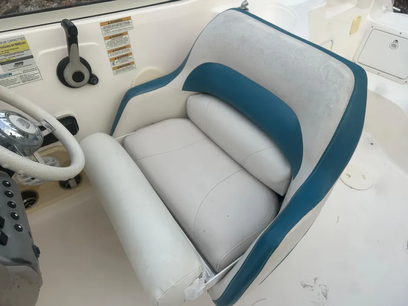 Slide: The Image of Captain's seat of a 2007 Hurricane SunDeck 237 OB boat, featuring blue and white upholstery. - 19