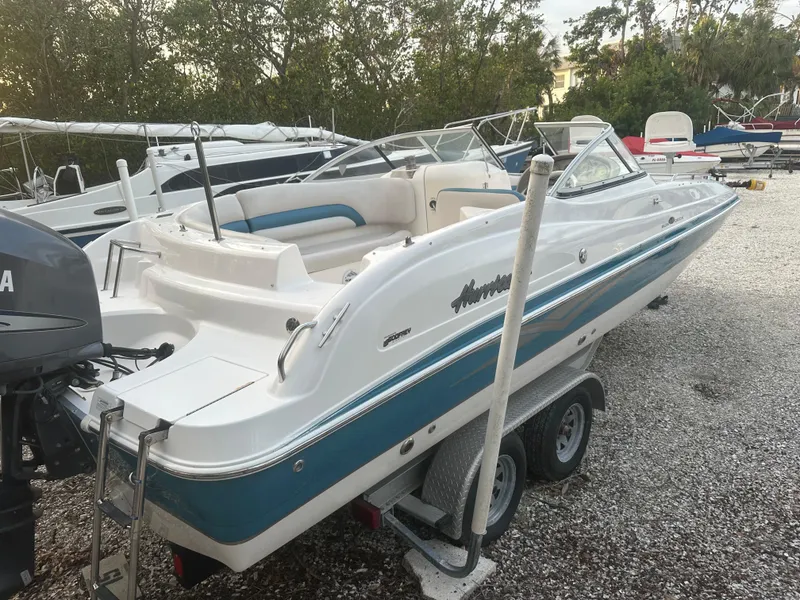 Slide: The Image of 2007 Hurricane SunDeck 237 OB boat on trailer, white and blue design, parked outdoors. - 3