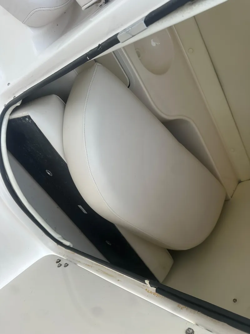 Slide: The Image of 2007 Hurricane SunDeck 237 OB boat storage compartment with white cushioned seat. - 42